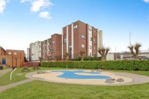 a park with a pond in front of a building at Pancinos Guest House Newmarket High Street in Newmarket