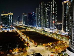 Blick auf eine Stadt in der Nacht mit hohen Gebäuden in der Unterkunft Cozy Stay #Songdo Dalbit Festival Park in Incheon