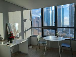 einen Tisch und Stühle in einem Zimmer mit Fenstern in der Unterkunft Cozy Stay #Songdo Dalbit Festival Park in Incheon