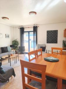 a living room with a wooden table and chairs at Playa Marina Phase I in Cabo Roig