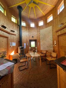 a large room with a table and chairs and a ceiling at STF Växhuset Hostel in Bodarne