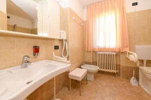un bagno con lavandino e WC di Hotel Bleis a Ponte di Legno Altre 69 foto
