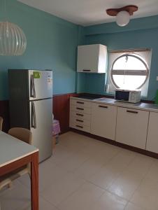 Una cocina con un refrigerador blanco y una ventana. en Lazaretto, T1, en Mindelo