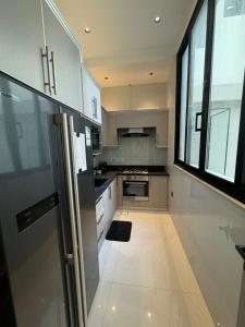 a kitchen with stainless steel appliances and a large window at شاليهات روح الخبر in Al Khobar