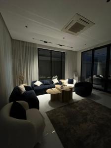 a living room with couches and a table and windows at شاليهات روح الخبر in Al Khobar +24 photos