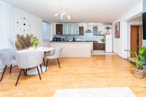 a kitchen and dining room with a table and chairs at D Apartments Čadca Centrum in Čadca
