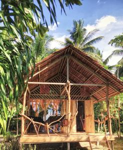 a small bamboo house with a thatched roof at Poki Poki - Togian Islands in Bomba