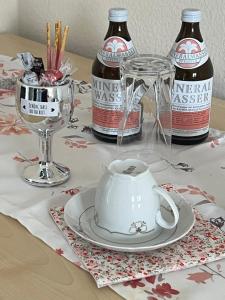 a table with a tea pot and two bottles of beer at Apartment Wohlfühl-Nest in Bürstadt
