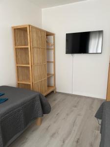 une chambre avec un lit et une télévision à écran plat sur un mur dans l'établissement revLIVING Lodge Kleinstelzendorf Hollabrunn - 4 Schlafzimmer, à Kleinstelzendorf