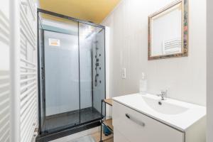 Un baño con ducha de cristal y lavabo. en gite D ETAPE DU PELERIN de la butte aux oiseaux, en Saint-Alban-sur-Limagnole
