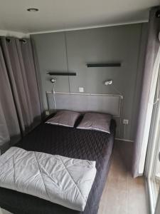 a bedroom with a large bed with two pillows at TRIGANO Savina 2022 in Litteau