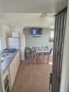 a kitchen and dining room with a table and a dining room at TRIGANO Savina 2022 in Litteau +1 photo