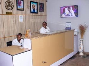 two people sitting at a counter in a room at Royal Dean Hotels & Suites in Mama