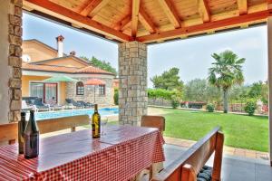 a table with two bottles of wine on a patio at Schöne Ferienvilla Morena Mit Pool in Kaštel
