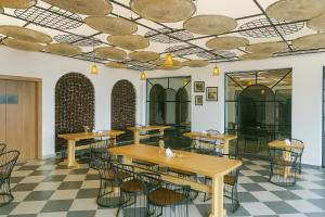 un ristorante con tavoli e sedie e un pavimento a scacchi di Kafal Pako Resort - Luxury Mountain View Stay in Mukteshwar a Mukteshwar