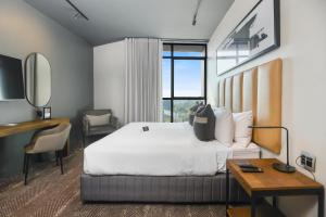 a hotel room with a large bed and a desk and a desk at The Capital Boardwalk in Gqeberha