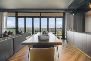 a dining room with a table and a couch at The Capital Boardwalk in Gqeberha