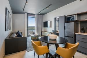 a kitchen and living room with a table and chairs at The Capital Boardwalk in Gqeberha