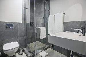 a bathroom with a toilet and a sink and a shower at The Capital Boardwalk in Gqeberha