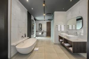 a large bathroom with two sinks and a large tub at The Capital Boardwalk in Gqeberha +17 photos