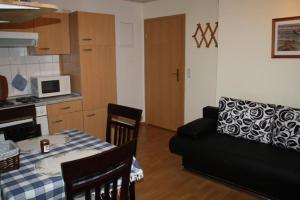 黑灵斯多夫Ferienwohnung In Ruhigem Ferienhaus In Ahlbeck的一间厨房和一间带桌子和沙发的客厅