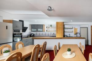 a kitchen and dining room with wooden tables and chairs at Penzion Hendrych in Vrchlabí