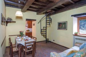 ein Wohnzimmer mit Tisch und Wendeltreppe in der Unterkunft Freistehendes Agriturismo in der Toskana für sechs Personen mit großem gemeinschaftlich genutzten Garten und Pool in Pratovecchio