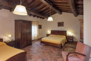 1 Schlafzimmer mit 2 Betten und 2 Stühlen in der Unterkunft Freistehendes Agriturismo in der Toskana für sechs Personen mit großem gemeinschaftlich genutzten Garten und Pool in Pratovecchio + 31 Fotos