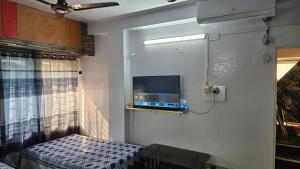 Una habitación con una cama y un televisor en la pared. en Sky Garden Home, en Dhaka