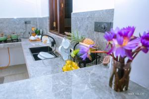 eine Vase mit lila Blumen auf einer Theke in einer Küche in der Unterkunft Zeyora Mirissa in Mirissa + 95 Fotos