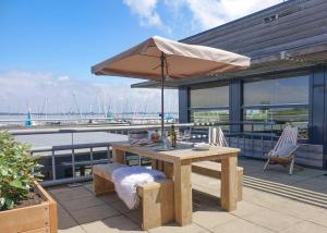 a wooden table with an umbrella on a patio at Dock Hotel Stellendam in Stellendam