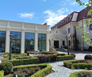 a building with a garden in front of it at Hotel Jarosław in Jarosław