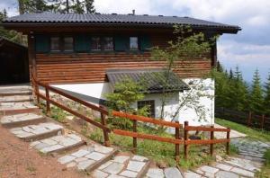 une maison avec une clôture en bois devant dans l'établissement Almhaus Am Hohenwart, à Klippitztorl