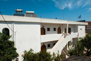 a white building with stairs on the side of it at Studios Margarita in Petalidhion