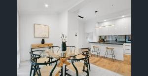 une salle à manger avec une table et des chaises en verre dans l'établissement Modern Tranquility in the heart of Tanunda, à Tanunda