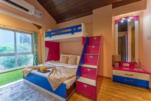 a bedroom with a bunk bed with a ladder and a bunk bedwered at Gauri Villa by ELIVAAS 3-BHK Villa With Private Pool, Lounge, Garden & Bathtub With 360 Panoramic Hill Views Near Waterfalls in Kasāra