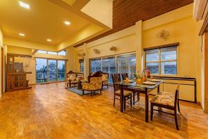 a large living room with a table and chairs at Gauri Villa by ELIVAAS 3-BHK Villa With Private Pool, Lounge, Garden & Bathtub With 360 Panoramic Hill Views Near Waterfalls in Kasāra