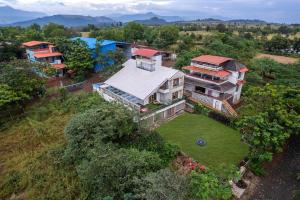 an aerial view of a house with a yard at Gauri Villa by ELIVAAS 3-BHK Villa With Private Pool, Lounge, Garden & Bathtub With 360 Panoramic Hill Views Near Waterfalls in Kasāra
