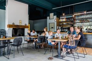 eine Gruppe von Menschen, die an Tischen in einem Restaurant sitzen in der Unterkunft Vakantiepark BreeBronne in Maasbree