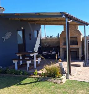 a patio with a table and a picnic table at Korhaansnest in Vredenburg