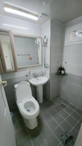 慶州市にある황리단길 대릉원 천마총 도보 5분 아늑한 퀸침대 투룸 3-1の白いトイレと洗面台のあるバスルーム