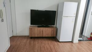慶州市にある황리단길 대릉원 천마총 도보 5분 아늑한 퀸침대 투룸 3-1の冷蔵庫の横にある木製の台の上に置かれたテレビ