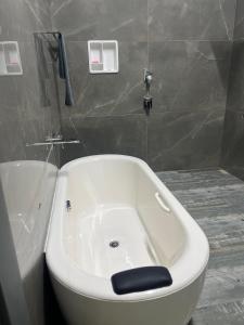 La salle de bains est pourvue d'une baignoire blanche. dans l'établissement Sirilaka Wedagedara, à Alutwala