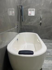 La salle de bains est pourvue d'une baignoire blanche et d'une douche. dans l'établissement Sirilaka Wedagedara, à Alutwala