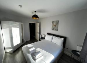 a bedroom with a bed with white sheets and a window at Abbey Apartments in Dublin