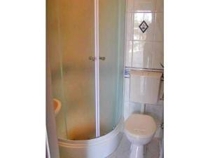 ein Badezimmer mit Dusche und Toilette in der Unterkunft Ferienhaus mit Terrasse und Kinderpool an einer Bucht mit Meerblick in Rogoznica