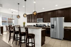a kitchen with wooden cabinets and a refrigerator at 5 Bedrooms 5 Bathrooms Crystal Cove 1042Td in Kissimmee