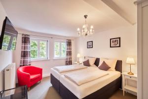 une chambre avec un lit et une chaise rouge dans l'établissement Schloss - Schenke Tunzenberg, à Mengkofen