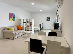 a living room with a table and a couch at Geysotur Torrox Playa Apartamentos in Torrox