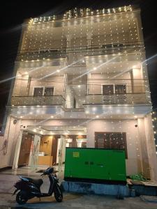 Hotal Glory Ganga في حاريدوار: سكوتر متوقف أمام مبنى به أضواء